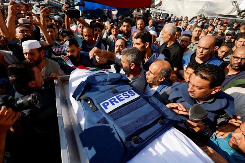 Periodistas palestinos trabajando en Gaza entre edificios destruidos durante la ofensiva israelí